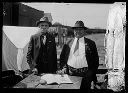 Two men with book and pen, 8/1925, #10261_1