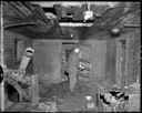 Fireman inspecting house fire scene, 307 Spruce St., 1/27/55, #28873_1