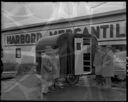 Four men view small trailer at Harbord Mercantile, 4/15/55, #29163_1