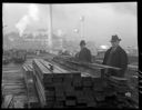 Two men in sawmill yard with cinders on lumber, 3/29/1934, #15207_1