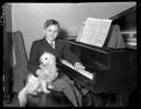 Boy genius Conrad Wise at piano with dog, 3/25/1938, #15472_1