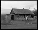 Native American home exterior with two women at Taholah, 1/27/1942, #19115_1