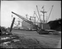 Mobile crane lifting logs at dock, 2/19/1964, #45374_1