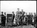 Group on dock with two divers, circa 1920, #G0622_1