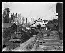 Logs on railroad carriages outside sawmill, circa 1922, #G1040_1