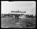 Crowd with TENPAISAN MARU aground, breeches buoy returns empty to ship, 11/24/1927, #G1143_1