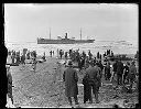 Crowd with TENPAISAN MARU aground, rescue line for breeches buoy is rigged, 11/24/1927, #G1147_1