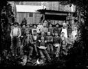 Group of loggers with child and photos, circa 1907, #G0675_1