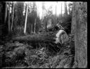 Man seated on log with dog, circa 1910, #G1450_1