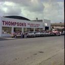 Thompson's Welding & Logging Supplies exterior with trucks and staff, 8/3/1979, #65583_1