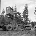 A truck mounted loader loads a log truck
<br/>
, 9/1970, #57099_1