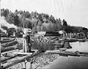 Tug towing barge and men working on log raft, 3/7/1926, #L400516_1