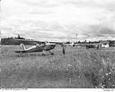 Aircraft and man at a rural grass airstrip, 7/4/1948, #L31R6F34_1