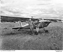 Aircraft and man at a rural grass airstrip, 7/4/1948, #L31R6F35_1